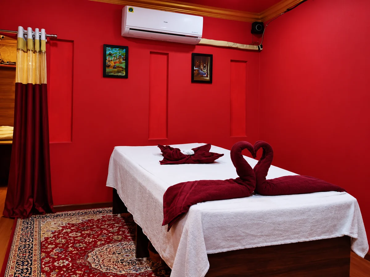 Aroma’s single-bed room with red walls and white linen